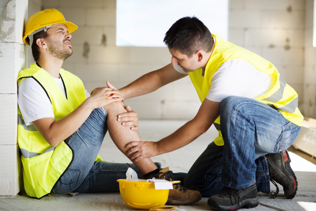 a stock image of a construction worker helping his injured colleague