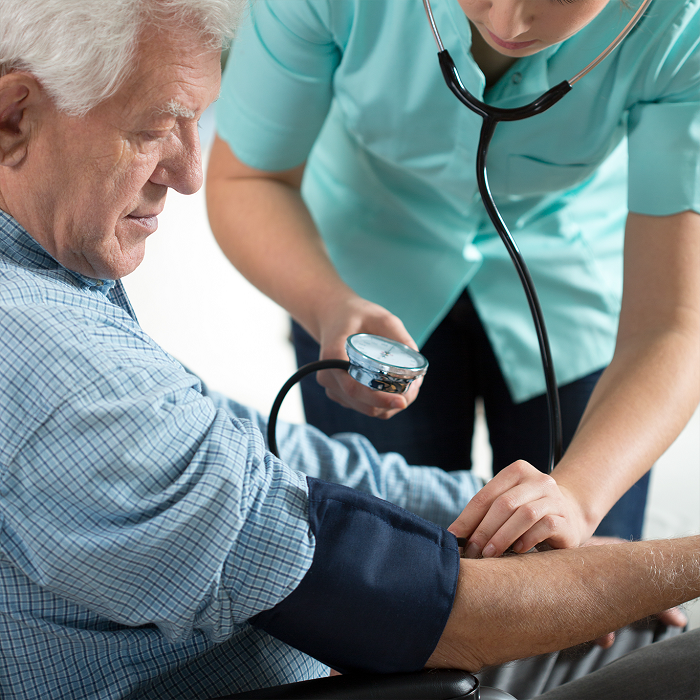 a nurse taking an old man's blood pressure